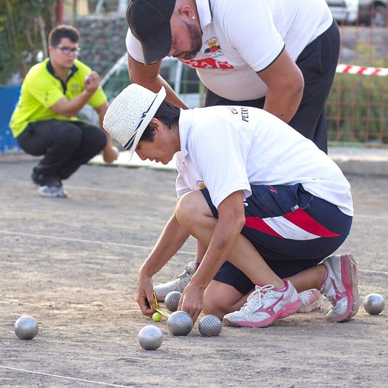 árbritra midiendo para puntuar en la petanca durante las fiestas patronales de Carrizal de Ingenio