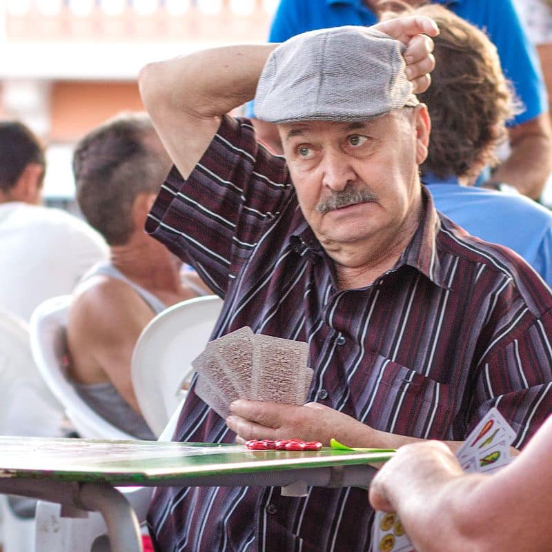 señor con boina y bigote jugando en un torneo de zanga