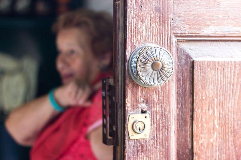 señora hablando detrás de una puerta